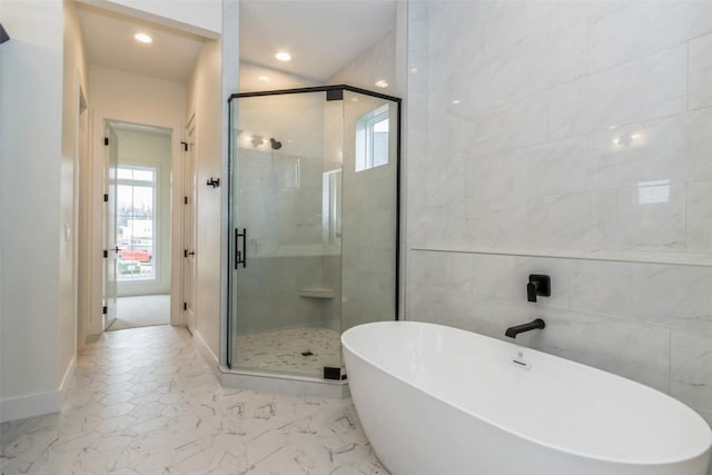 bathroom featuring shower with separate bathtub