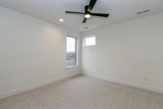 unfurnished room with light colored carpet and ceiling fan