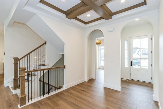 foyer entrance featuring beam ceiling, wood-type flooring, and coffered ceiling