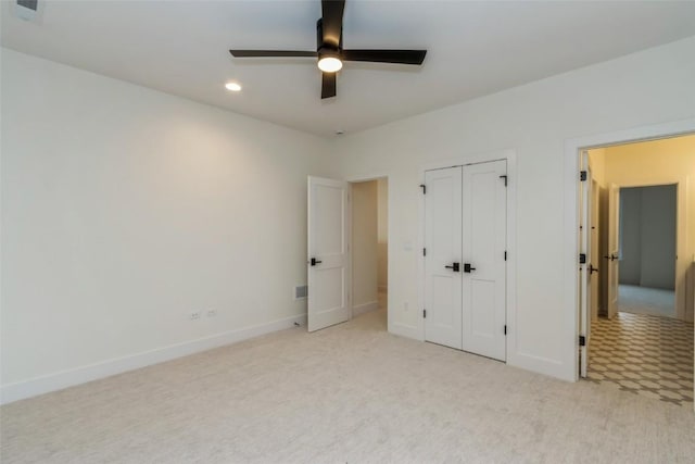 unfurnished bedroom featuring light colored carpet and ceiling fan