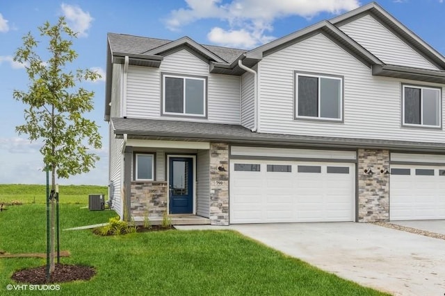 view of front of house featuring a front yard, central AC, and a garage