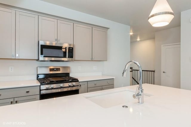 kitchen featuring gray cabinetry, sink, and appliances with stainless steel finishes