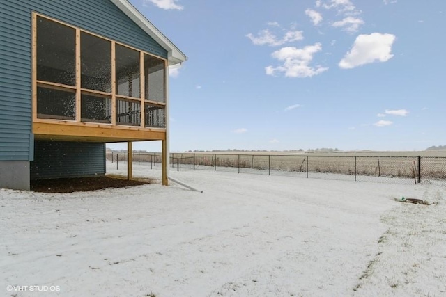 yard covered in snow featuring a rural view