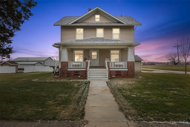 view of front of property with a porch and a yard