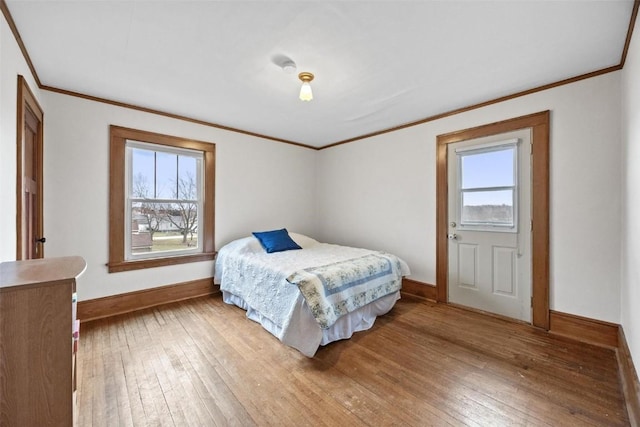 bedroom with hardwood / wood-style floors, crown molding, and multiple windows