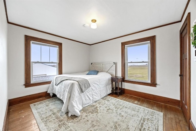 bedroom with dark hardwood / wood-style floors, multiple windows, and crown molding