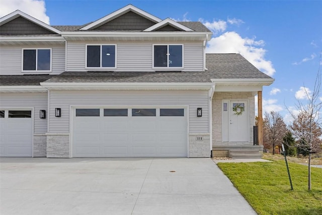 craftsman inspired home with a garage and a front yard