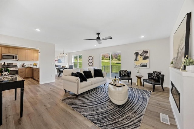 living room with light hardwood / wood-style floors and ceiling fan