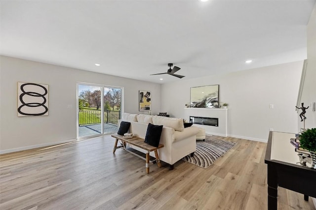 living room with light hardwood / wood-style floors and ceiling fan