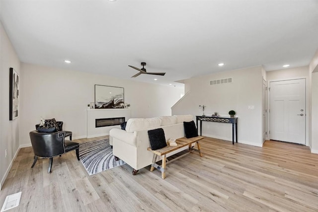 living room featuring ceiling fan and light hardwood / wood-style floors