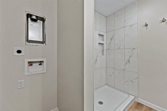 bathroom featuring wood-type flooring and tiled shower