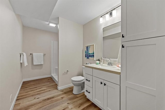 bathroom with a shower, vanity, wood-type flooring, and toilet