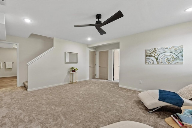 living area featuring ceiling fan and light colored carpet