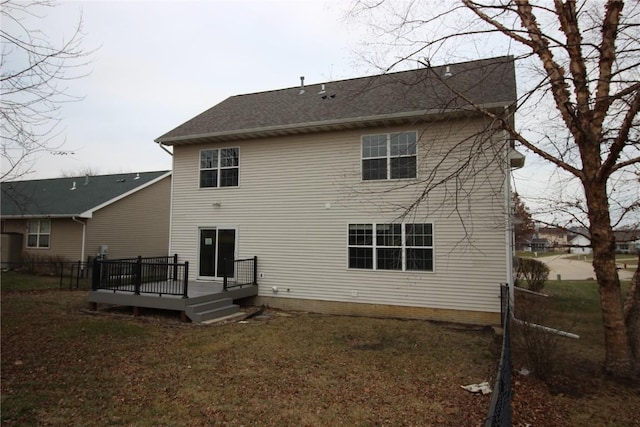 rear view of property featuring a lawn and a wooden deck