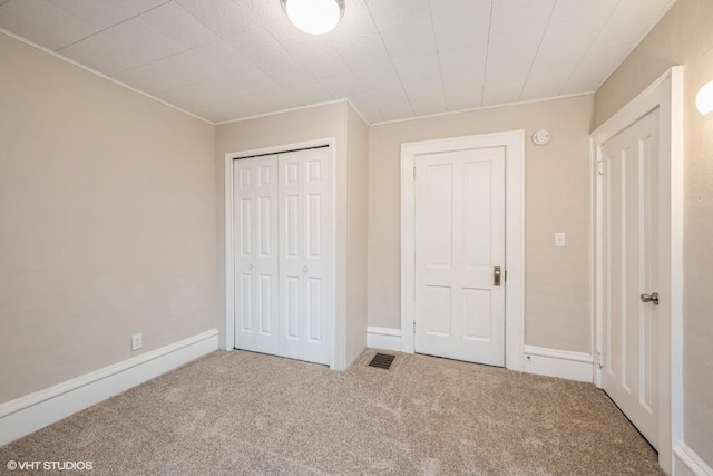 unfurnished bedroom featuring carpet flooring and a closet