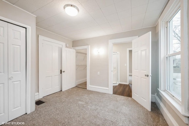 unfurnished bedroom featuring carpet floors and multiple windows