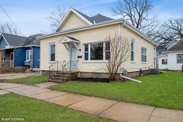 bungalow-style home with central AC unit and a front yard