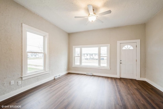 entrance foyer with a wealth of natural light, dark hardwood / wood-style flooring, ceiling fan, and a textured ceiling