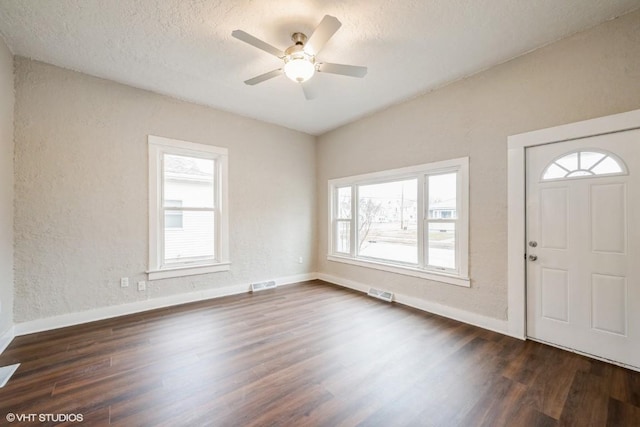 entrance foyer featuring a textured ceiling, dark hardwood / wood-style flooring, a wealth of natural light, and ceiling fan