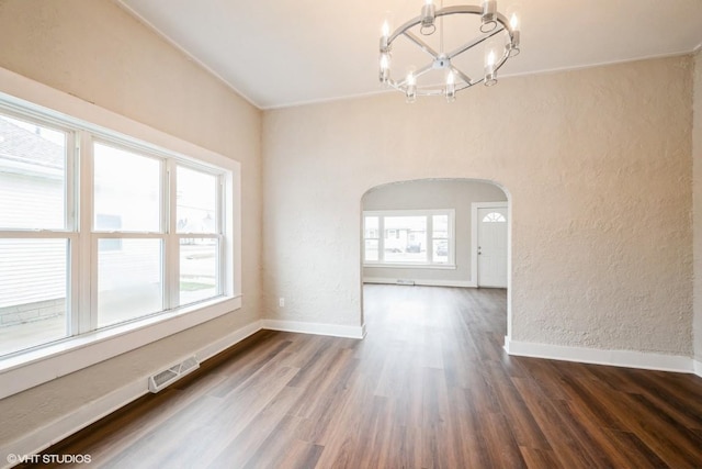 unfurnished dining area with dark hardwood / wood-style flooring and an inviting chandelier