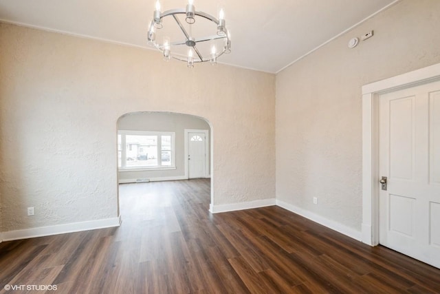 unfurnished room featuring dark hardwood / wood-style flooring and an inviting chandelier