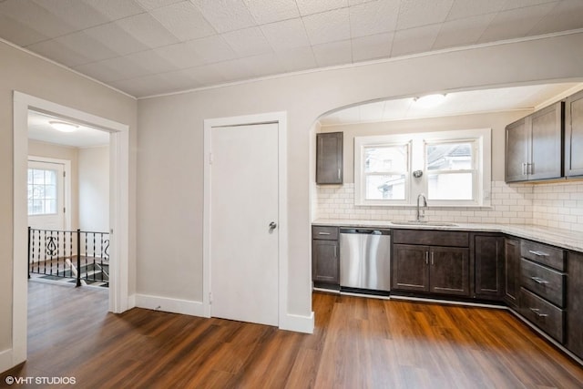 kitchen featuring dishwasher, sink, tasteful backsplash, dark hardwood / wood-style flooring, and dark brown cabinets