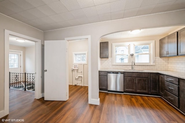 kitchen with tasteful backsplash, dark brown cabinetry, dishwasher, and sink