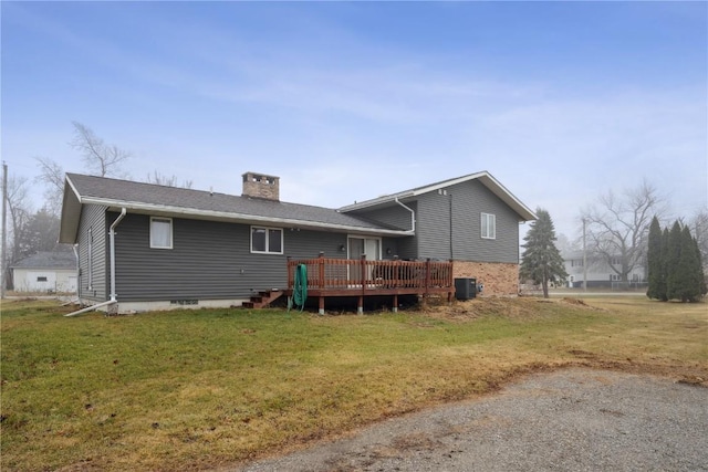 rear view of house featuring a lawn, central air condition unit, and a deck