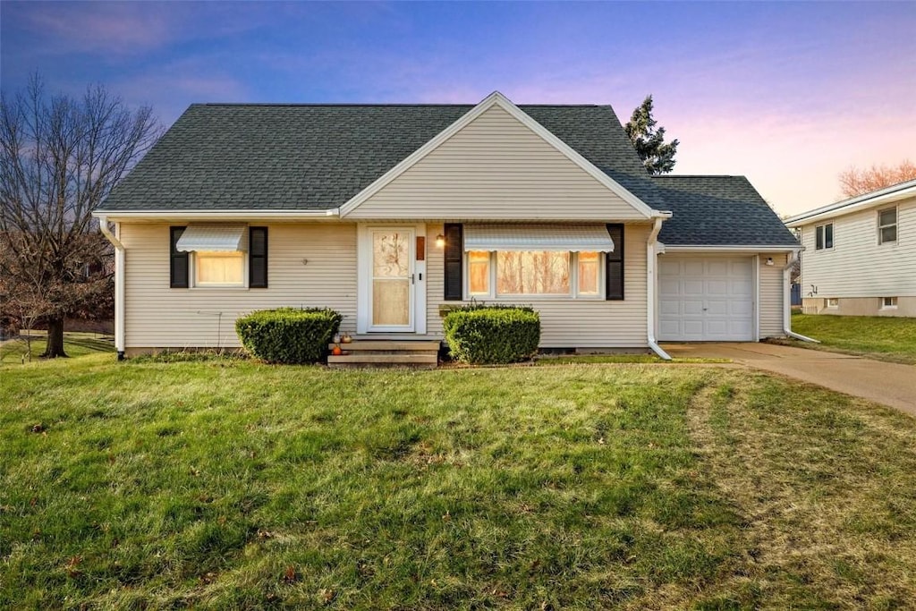 view of front of house featuring a garage and a lawn