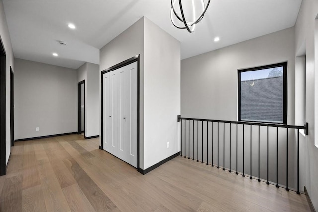 hall featuring an inviting chandelier and light hardwood / wood-style flooring