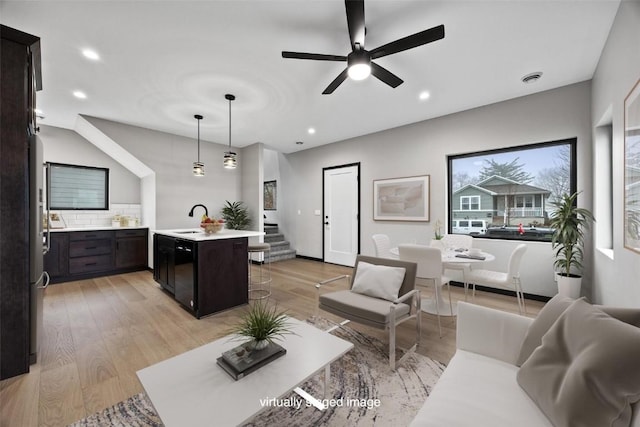 living room featuring ceiling fan, sink, and light hardwood / wood-style flooring