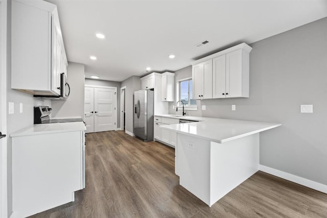 kitchen featuring white cabinets, stainless steel fridge with ice dispenser, kitchen peninsula, and dark wood-type flooring