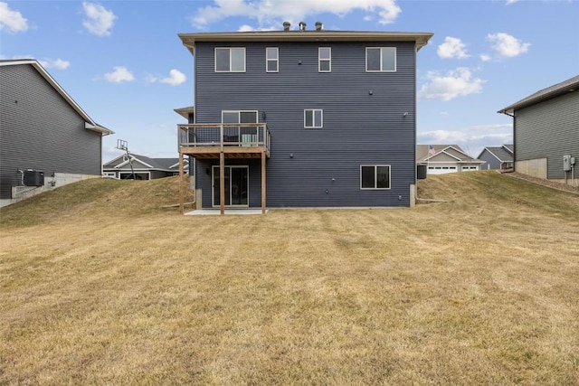 rear view of property with a wooden deck and a yard