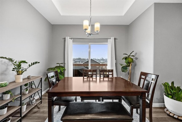 dining area with wood-type flooring and a notable chandelier