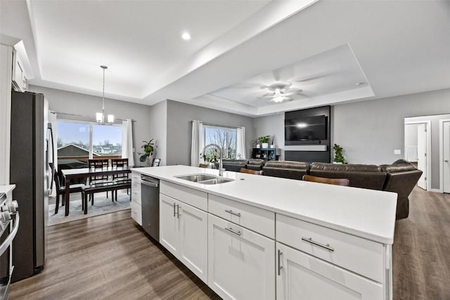 kitchen with white cabinets, stainless steel appliances, a raised ceiling, and sink