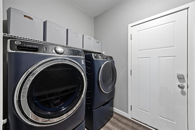 washroom with washing machine and dryer and dark hardwood / wood-style floors