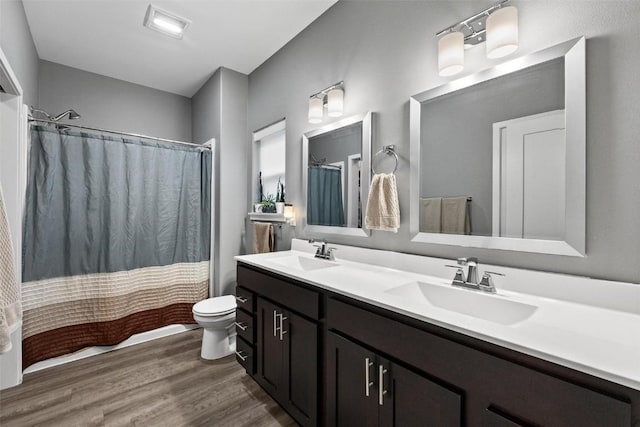 bathroom with hardwood / wood-style floors, vanity, and toilet