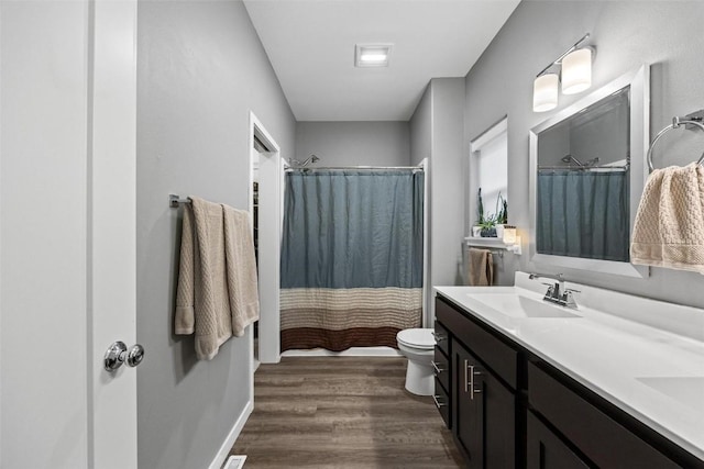 bathroom with a shower with curtain, vanity, wood-type flooring, and toilet