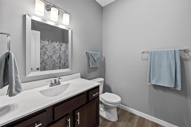 bathroom featuring hardwood / wood-style floors, vanity, toilet, and a shower with curtain