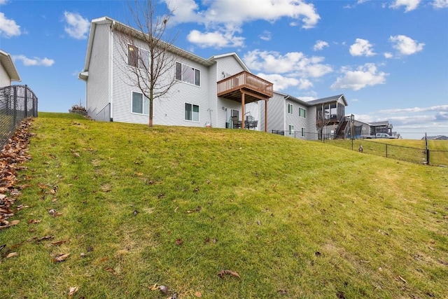 rear view of property featuring a lawn and a deck