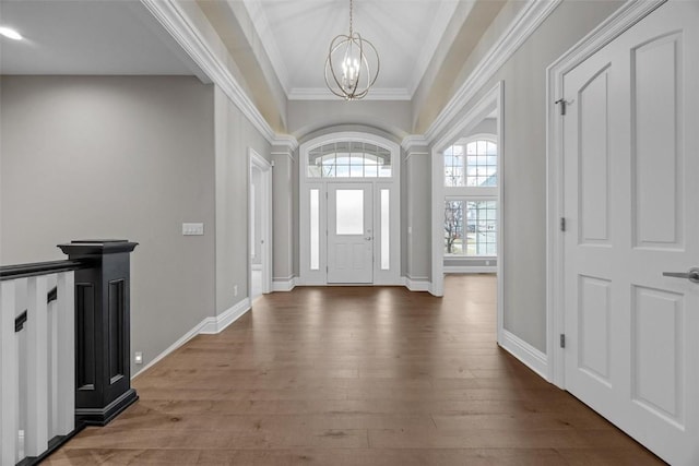 foyer with crown molding, a chandelier, and hardwood / wood-style flooring