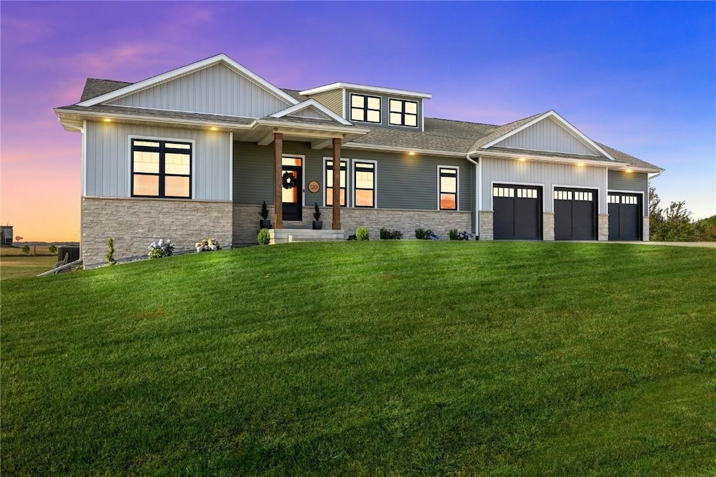 craftsman house featuring a garage and a yard