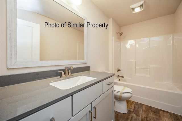 full bathroom with hardwood / wood-style flooring, vanity, toilet, and shower / washtub combination