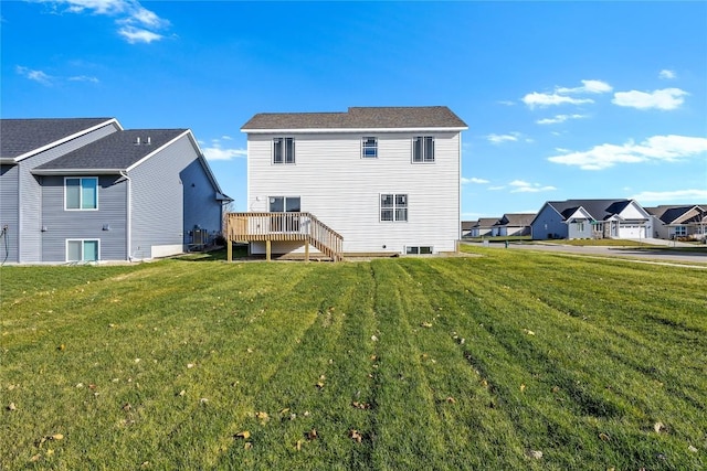 rear view of house featuring a lawn and a wooden deck