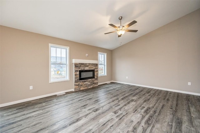 unfurnished living room featuring a stone fireplace, ceiling fan, hardwood / wood-style floors, and lofted ceiling