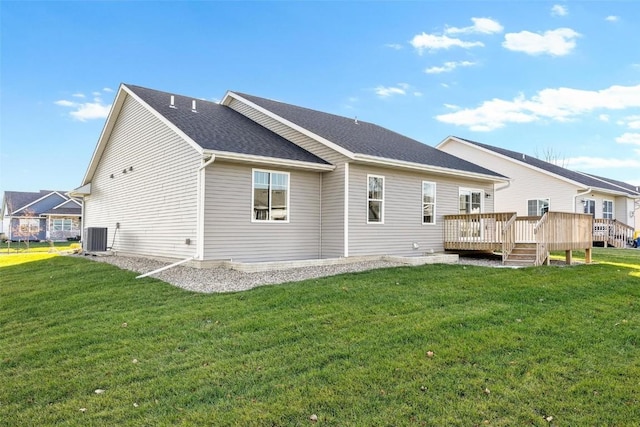 back of property with cooling unit, a yard, and a wooden deck