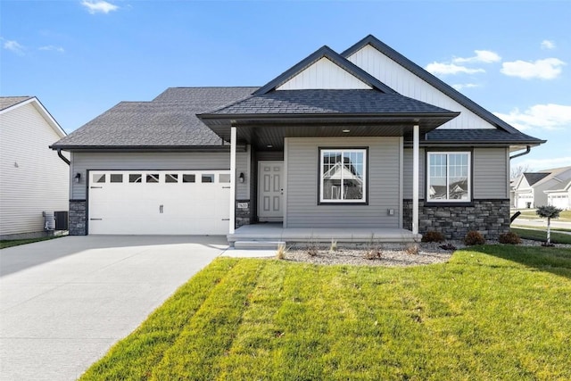 craftsman-style home featuring central air condition unit, a porch, a front yard, and a garage