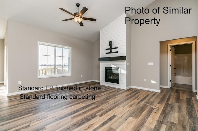 unfurnished living room with hardwood / wood-style floors, ceiling fan, a large fireplace, and lofted ceiling