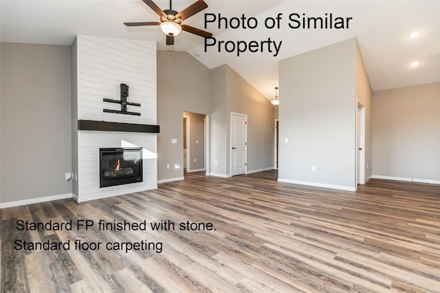 unfurnished living room featuring ceiling fan, a large fireplace, high vaulted ceiling, and hardwood / wood-style flooring