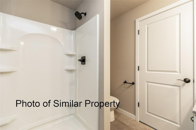 bathroom featuring a shower and toilet